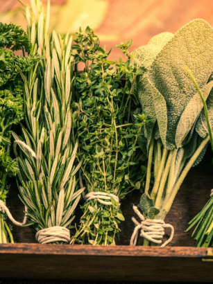 five bundles of herbs tied with string in wooden box